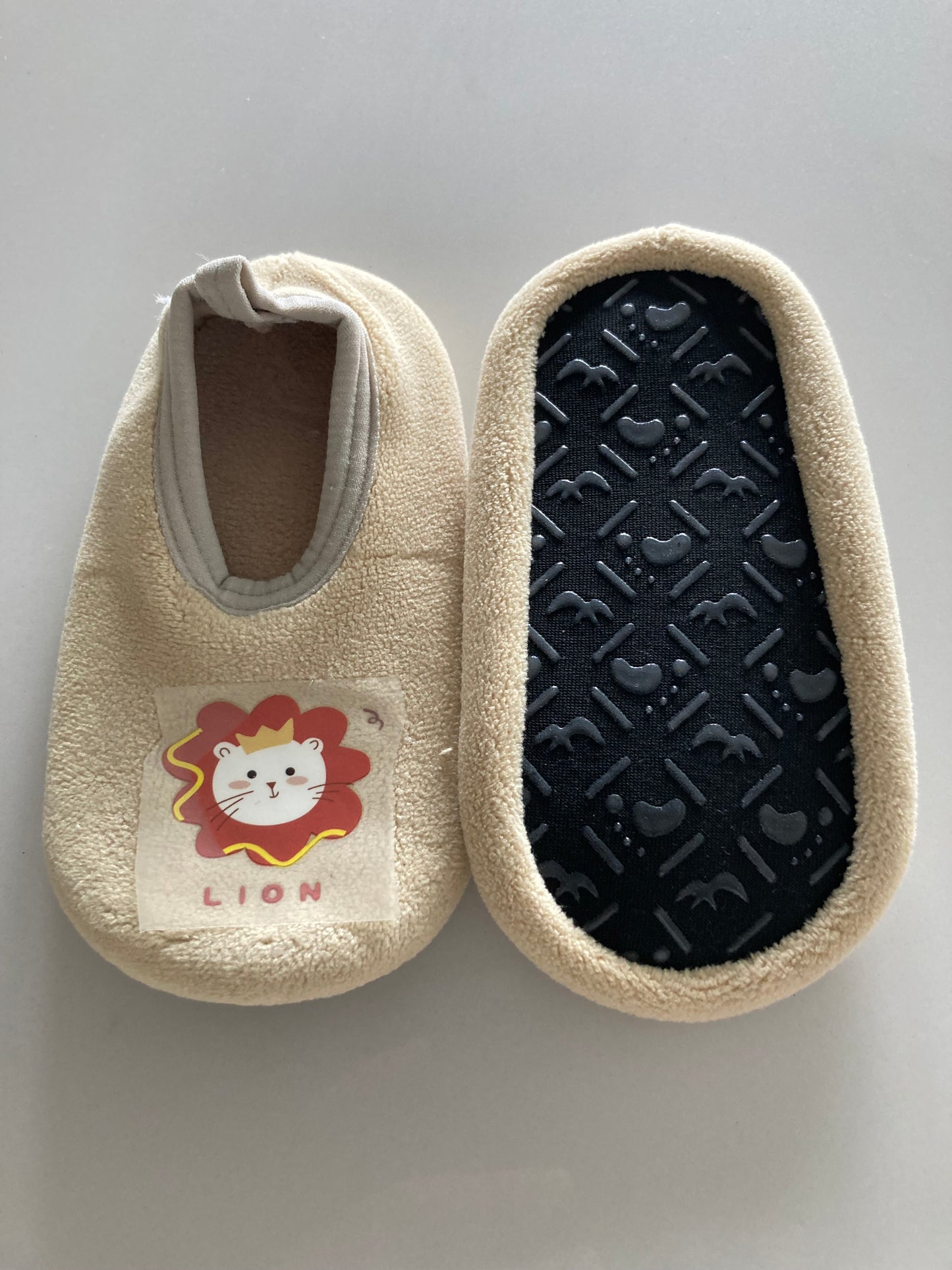 Velourse creme babyslofjes met leeuw